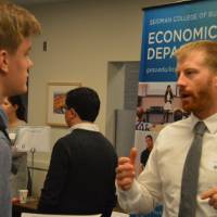 An alumnus talking to a student at the Academic Major Fair.